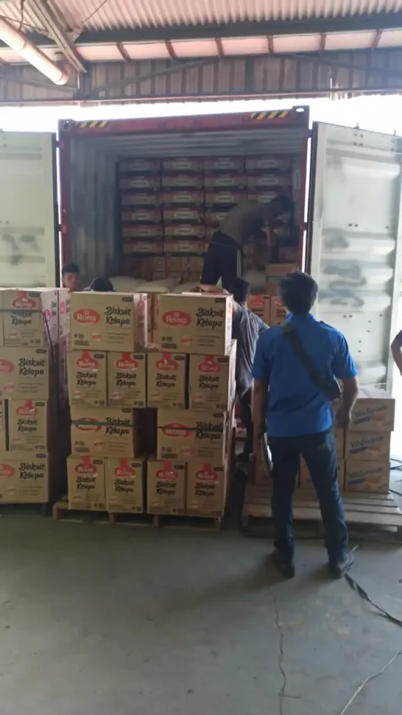 Warehouse workers loading Roma brand biscuit products into shipping container from Inti Mandiri Jayatama