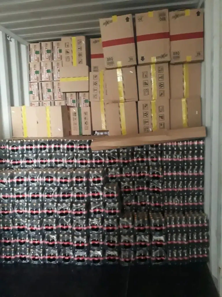 Shipping container loaded with beverage bottles and cardboard packaging for export by Inti Mandiri Jayatama