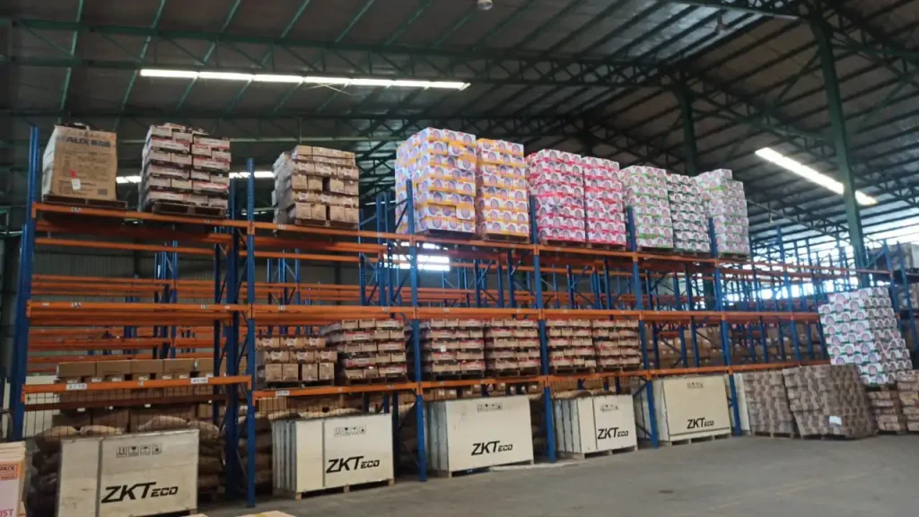 Industrial warehouse with multi-level storage racks and organized product inventory by Inti Mandiri Jayatama